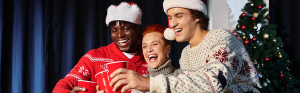 Коллеги празднуют Рождество вместе, делясь смехом и праздничными напитками в офисе.