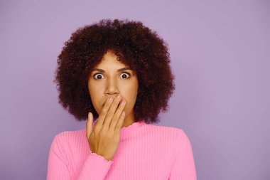 Pembeli, kıvırcık saçlı, hayat dolu bir ortamda afallamış Afro-Amerikan kadın..