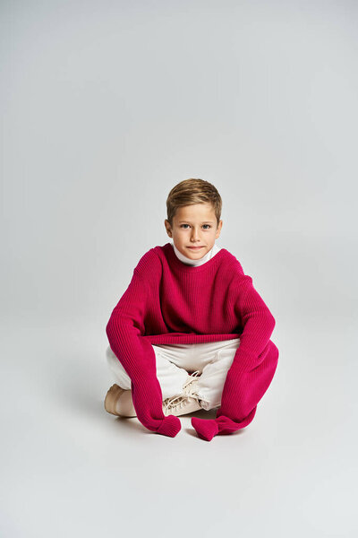 A young boy dressed in bright winter clothing enjoys a playful moment, expressing joy and warmth.