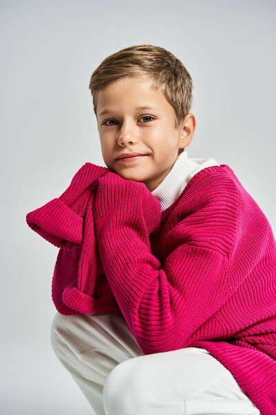 Молодой мальчик тепло одет в уютную зимнюю одежду, излучая игривую радость и комфорт.