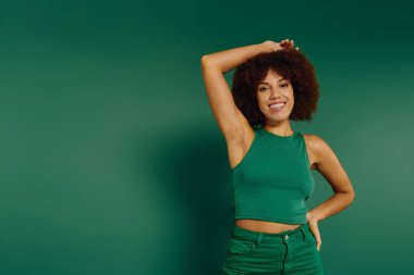 A young African American woman with curly hair radiates happiness against a vibrant green background. clipart