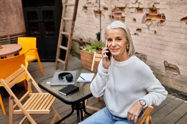 Güzel bir kadın büyüleyici bir kafede otururken bir telefon görüşmesi yapıyor..