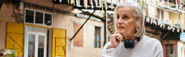 A thoughtful woman gazes into the distance, soaking up the vibrant urban atmosphere.