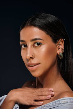 Esmer saçlı Afrikalı Amerikalı kadın mücevher sergiliyor.