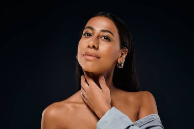 A beautiful African American woman with brunette hair highlights her beauty in a studio. clipart