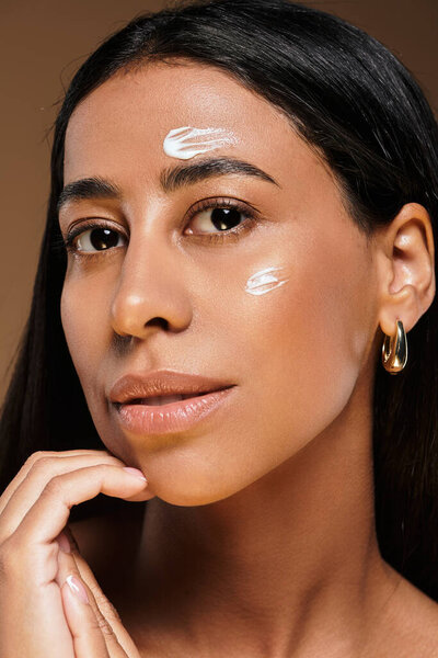 Женщина с брюнетками надевает кожу в хорошо освещенной студии, радуясь разнообразию красоты.