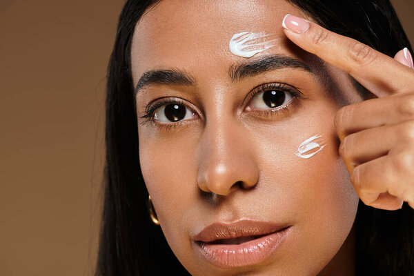 Женщина применяет средства по уходу за телом, подчеркивая многообразие красоты в студийной среде.