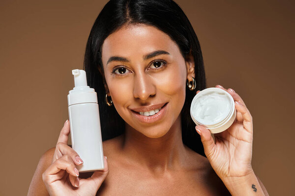 Красивая афроамериканка представляет продукты по уходу за кожей, улыбаясь в студии.