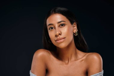 Esmer saçlı güzel bir Afrikalı Amerikalı kadın cilt bakımını ve güzellik çeşitliliğini ön plana çıkarıyor..