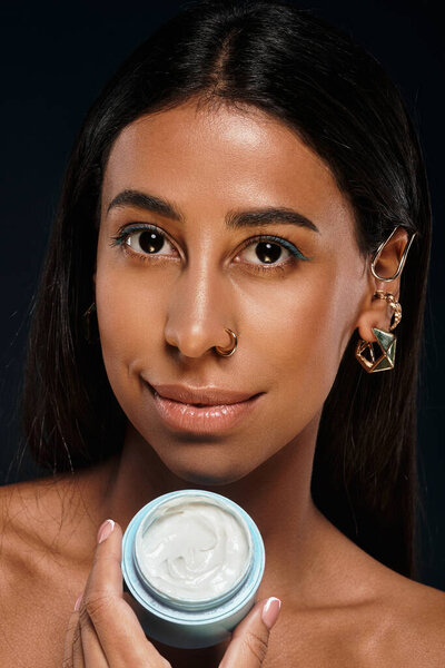 Женщина подчеркивает свою рутину по уходу за кожей, демонстрируя уход за телом в студии.