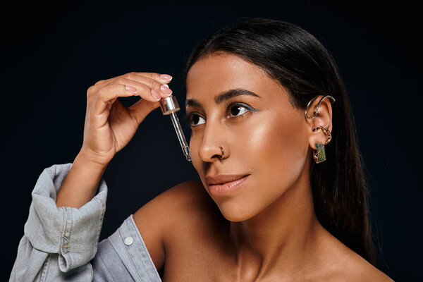 Красивая афроамериканка применяет сыворотку по уходу за кожей в студии с мягким освещением.