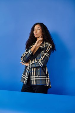 Zarif bir kadın dikkat çekici mavi bir ortamda moda anlayışını sergiliyor.