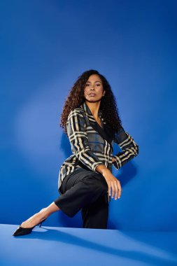 Güzel bir kadın zarafetini ve duruşunu sergilerken aynı zamanda eğlenceli bir poz veriyor.