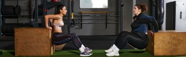 İki kadın spor yaparken spor salonundaki motivasyon ve zindeliği arttırır..