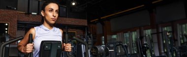 Güçlü bir kadın spor yaparken spor malzemelerini spor amaçlı kullanır.