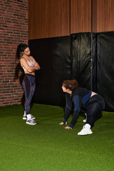 Две женщины подталкивают друг друга к успеху во время тренировки в современной спортивной среде.