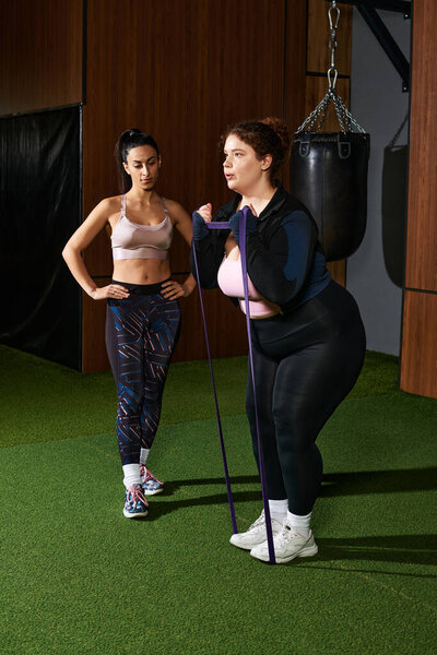 Две женщины участвуют в тренировке, одна тренирует другую в техниках тренировки сопротивления..