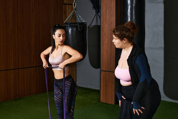 Two women focus on their resistance band workout in a contemporary fitness center.