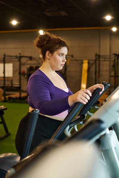 Фокус и решимость исходят от женщины, участвующей в тренировке в тренажерном зале.