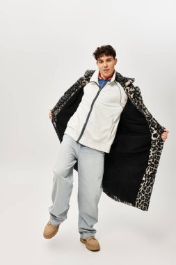 Yakışıklı bir adam iyi ışıklandırılmış, modern bir çevrede şık bir kıyafet sergiliyor..