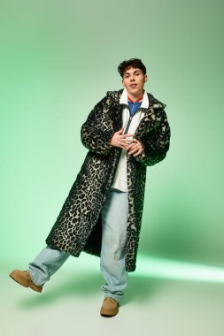 Yakışıklı adam modern bir ortamda leopar desenli bir ceket giyerek moda anlayışını sergiliyor..