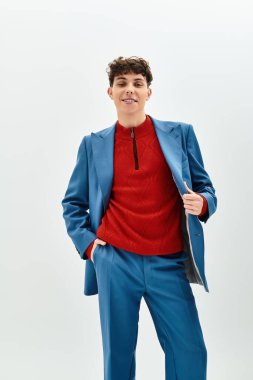 Handsome man poses confidently in a vibrant blue suit with a striking red sweater, exuding charm. clipart