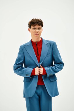 Yakışıklı adam dikkat çekici bir kıyafet sergiliyor, klasik ve modern moda eğilimlerini harmanlıyor.