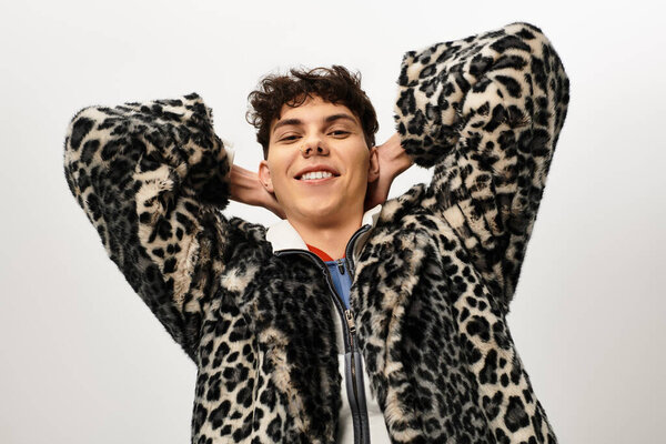 Красивый мужчина демонстрирует стильный стиль в шикарном леопардовом пиджаке, играя в позу.