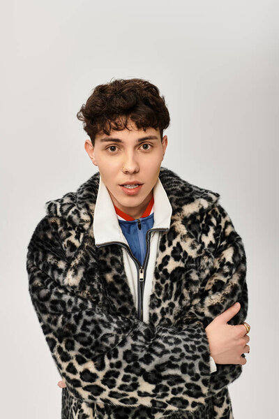 Красивый мужчина стоит со скрещенными руками, демонстрируя смелый выбор моды в леопардовой печати.