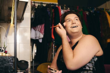 Bir travesti canlı bir soyunma odasında makyaj yapar, tatil programı için hazırdır..