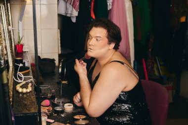 Hevesli travesti, tatil gösterisinden önce hareketli bir soyunma odasında görünüşünü güzelleştiriyor..