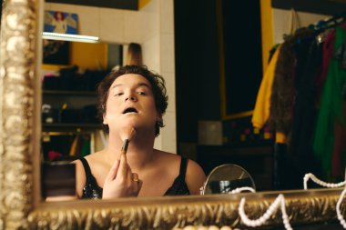 Canlı bir soyunma odasında, bir travesti dikkatlice bir tatil gösterisi için makyaj yapar..