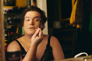 Bir travesti, tatil gösterisi için hazırlanırken sahne arkasına makyaj yapar..