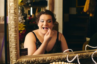 Bir travesti renkli bir soyunma odasında canlı bir makyaj yapar, tatil gösterisi için hazırdır..