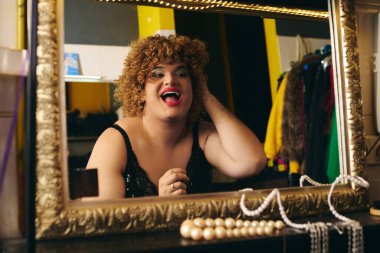 Canlı bir soyunma odasında, bir travesti makyaj yapar, tatil gösterisine hazırlanır..