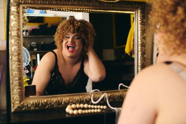 Bir travesti, sahne arkasında heyecan verici bir tatil gösterisine hazırlanmak için ustaca makyaj yapar..