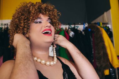 Soyunma odasında, aksesuar takan bir travesti.