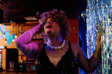 Yetenekli bir travesti, neşeli bir tatil programında sahneye canlı bir makyajla elektrik veriyor..
