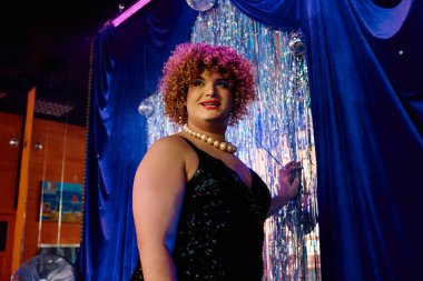 Bir travesti, seyirciyi cesur makyajları ve abartılı kıyafetleriyle cezbeder..