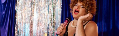 Bir travesti sahnede büyüleyici bir performansla kalabalığı büyülüyor, çeşitliliği kucaklıyor..