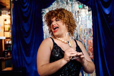 Cesurca giyinmiş travesti karizmayla gösteri yapıyor, tatil programı izleyicilerine neşe getiriyor..