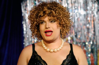Bir travesti, dinleyicileri canlı bir makyaj ve tarzla büyüler, sahnede çeşitliliği kutlar..
