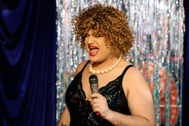 Cesur makyajlı bir travesti, seyirciyi büyüleyen canlı bir tatil şovu yapar..