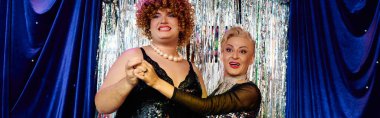 İki çarpıcı travesti, bir tatil kutlamasında canlı bir makyajla birlikte gösteri yapıyorlar..