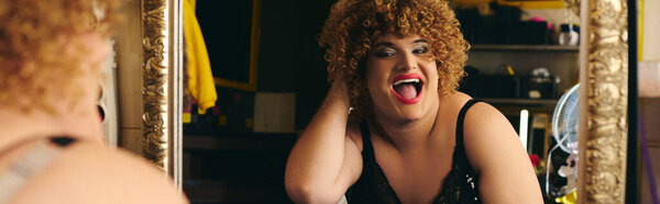 Preparing for a holiday show, the drag queen showcases artistic makeup skills near a mirror.