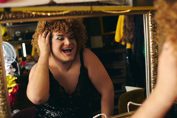 Applying makeup with care, a drag queen prepares for an extravagant holiday performance.