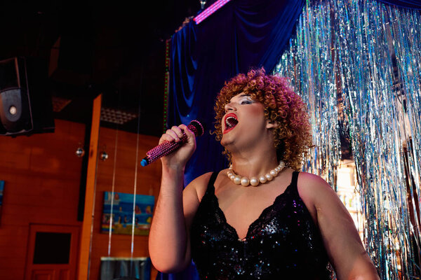 A talented drag queen wows the crowd with striking makeup and an amazing vocal performance.