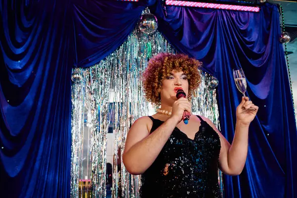 Canlı bir tatil performansı sırasında cesur bir şekilde boyanmış travesti karizmasıyla eğleniyor..