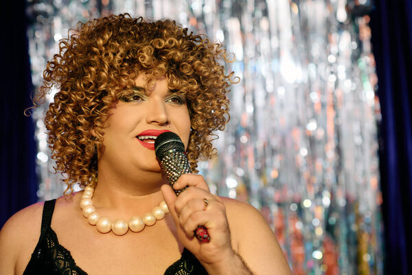 Смелый андрогинный исполнитель ослепляет своим экстравагантным макияжем и живо выступает на сцене.