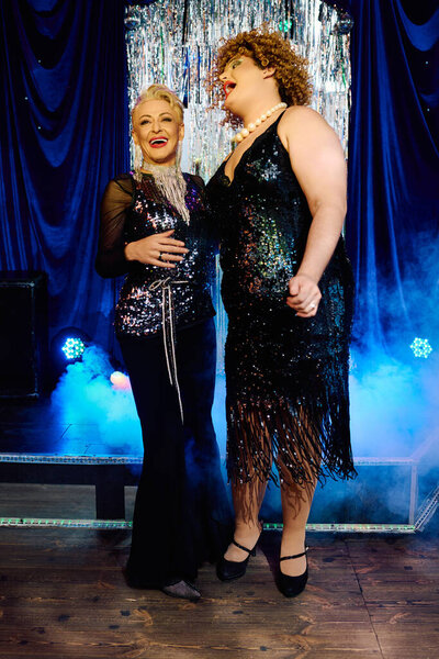 Две эксцентричные трансвеститы в потрясающем макияже очаровывают толпу своим динамичным дуэтом.